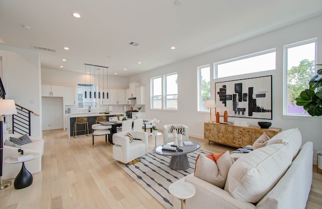 living room featuring sink and light hardwood / wood-style floors