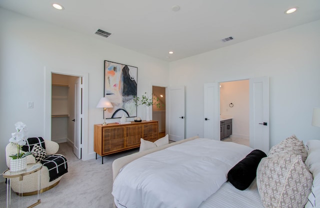 carpeted bedroom featuring ensuite bathroom and a spacious closet