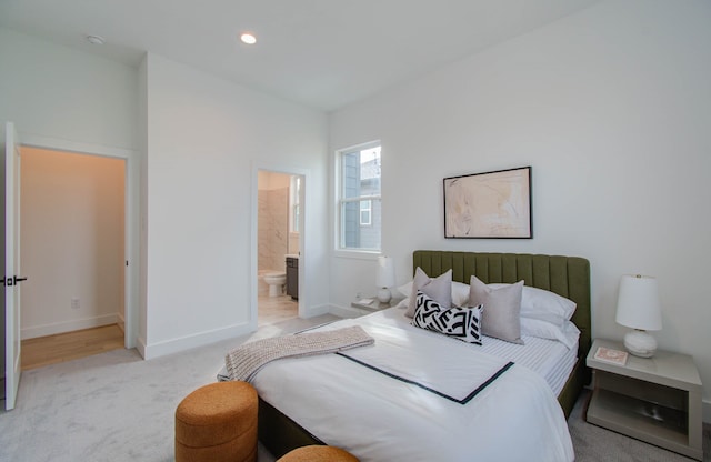 bedroom featuring light carpet and ensuite bathroom