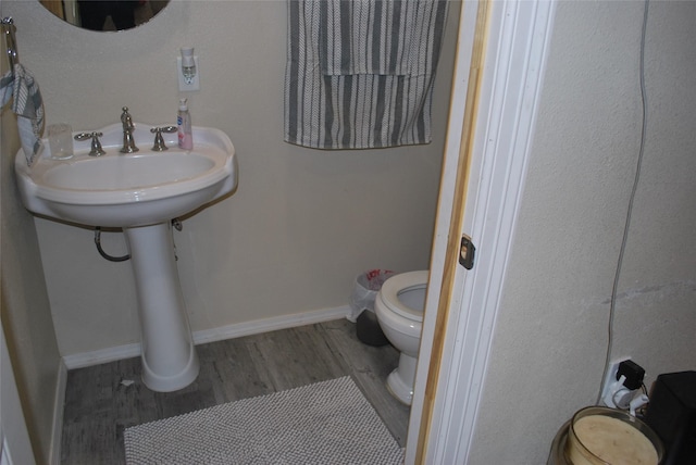 bathroom featuring hardwood / wood-style floors and toilet