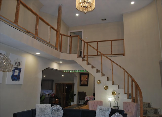 staircase with a high ceiling and a chandelier