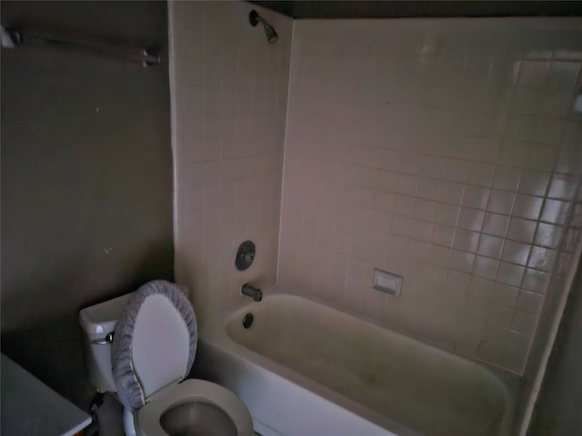 bathroom featuring tiled shower / bath combo and toilet