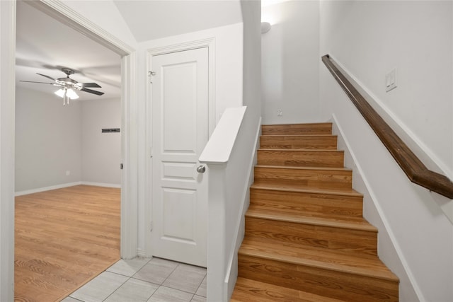 stairway with tile patterned floors and ceiling fan