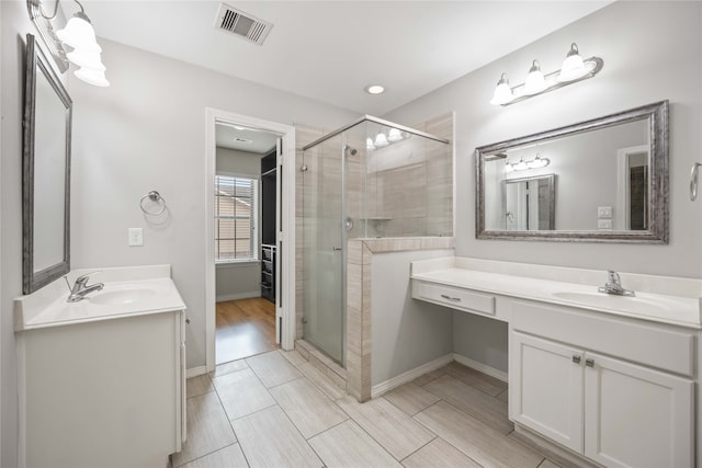 bathroom with vanity and a shower with door