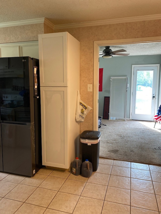 kitchen with ornamental molding, a textured ceiling, black refrigerator, ceiling fan, and light colored carpet