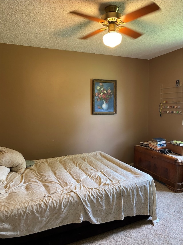 bedroom featuring ceiling fan, carpet, and a textured ceiling