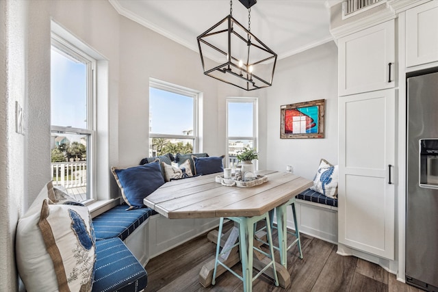 dining area featuring an inviting chandelier, dark hardwood / wood-style floors, and crown molding