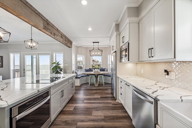 kitchen with a notable chandelier, appliances with stainless steel finishes, and white cabinetry