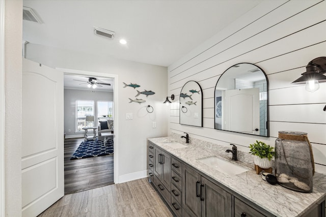 bathroom with wood walls, vanity, ceiling fan, and hardwood / wood-style flooring