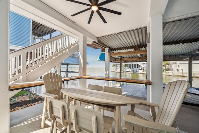 dining area with a water view and ceiling fan