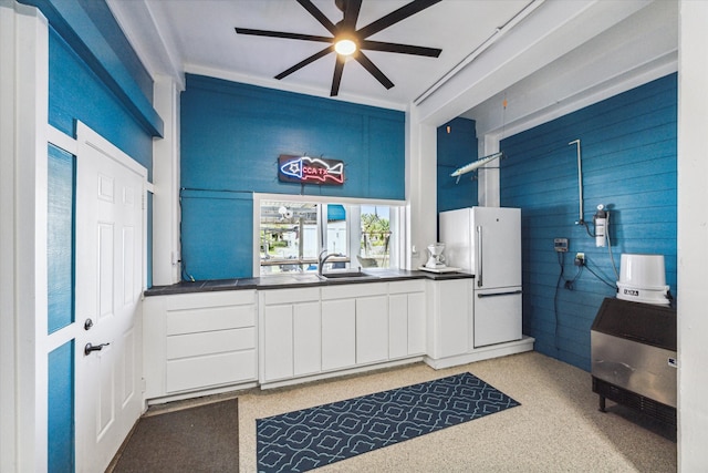 kitchen featuring white cabinetry, ceiling fan, white fridge, and sink