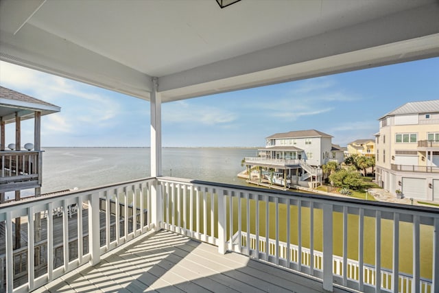 wooden terrace with a yard and a water view