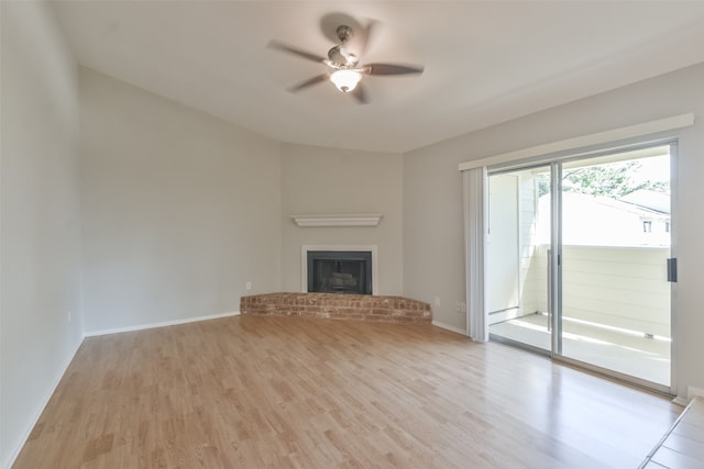 unfurnished living room featuring ceiling fan, a fireplace, and light hardwood / wood-style floors