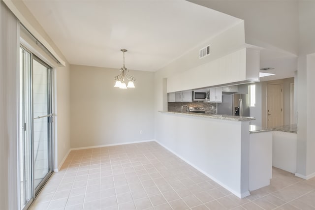 kitchen featuring a notable chandelier, decorative light fixtures, kitchen peninsula, appliances with stainless steel finishes, and light tile patterned flooring