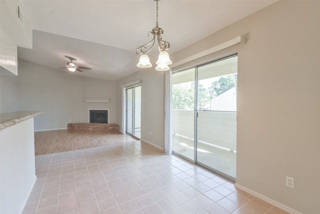 unfurnished living room featuring light wood-type flooring, ceiling fan with notable chandelier, and a brick fireplace