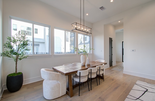 dining space featuring light hardwood / wood-style flooring and a notable chandelier