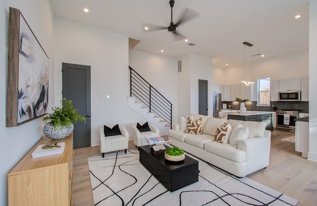 living room featuring light hardwood / wood-style flooring and ceiling fan