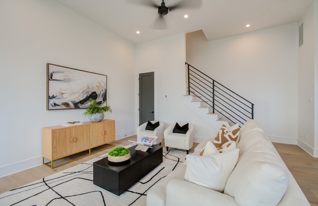 living room with ceiling fan and light hardwood / wood-style flooring