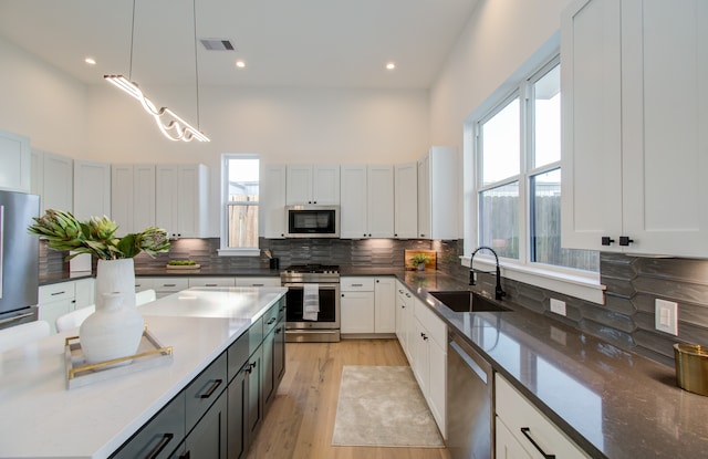 kitchen featuring a wealth of natural light, decorative light fixtures, stainless steel appliances, and sink