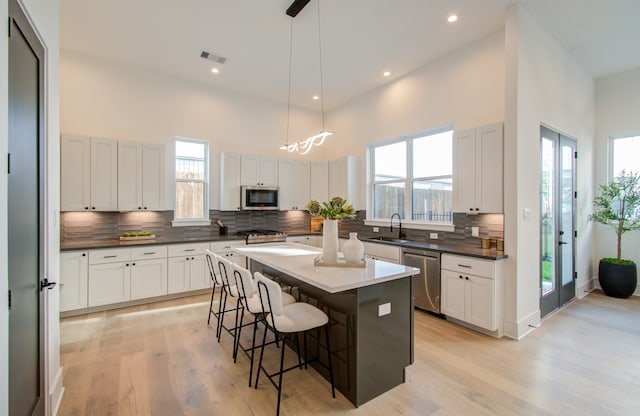 kitchen featuring plenty of natural light, a kitchen island, stainless steel appliances, and a breakfast bar