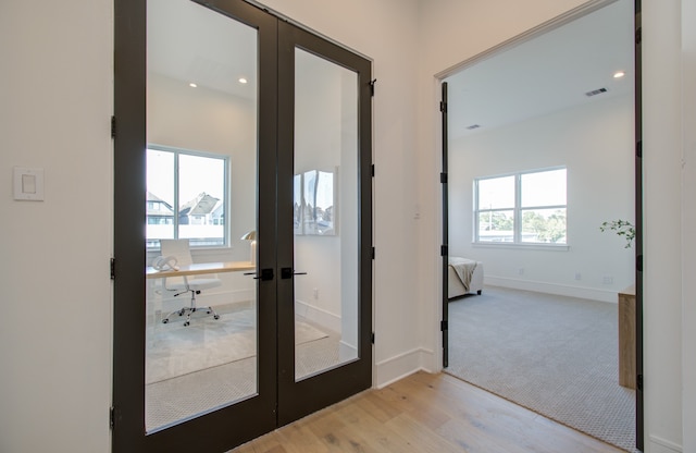 doorway featuring french doors, a wealth of natural light, and light hardwood / wood-style floors