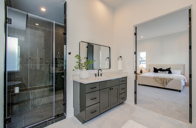 bathroom featuring tile patterned floors, a shower with door, and vanity