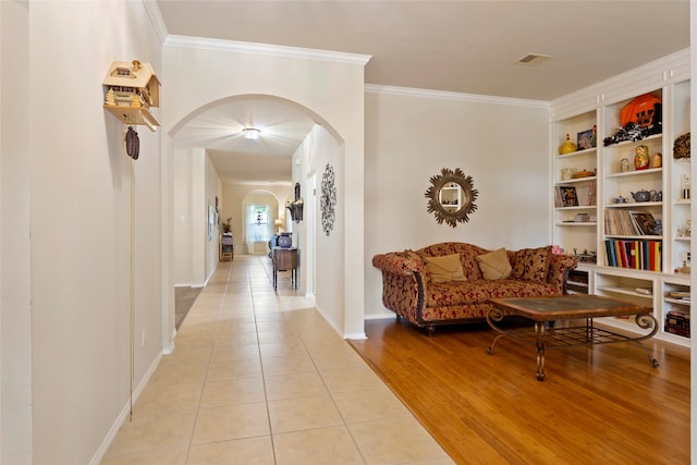 hall with light wood-type flooring and ornamental molding