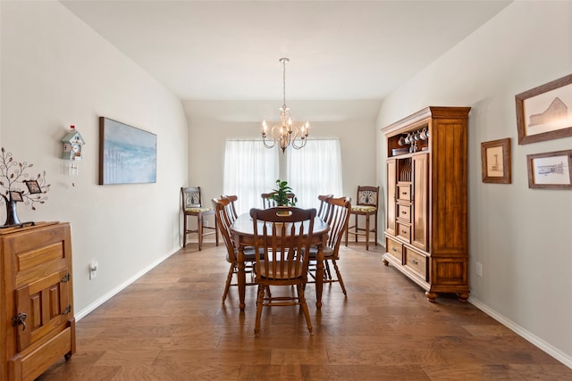 dining space with lofted ceiling, dark hardwood / wood-style flooring, and a notable chandelier