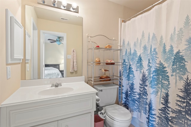 bathroom featuring a shower with shower curtain, vanity, toilet, and ceiling fan