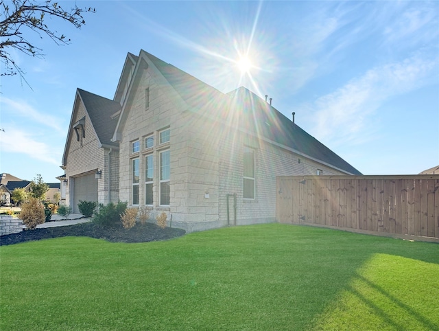 view of home's exterior with a garage and a yard