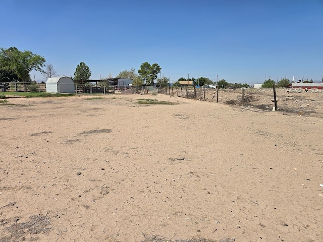 view of yard with a storage shed and a rural view