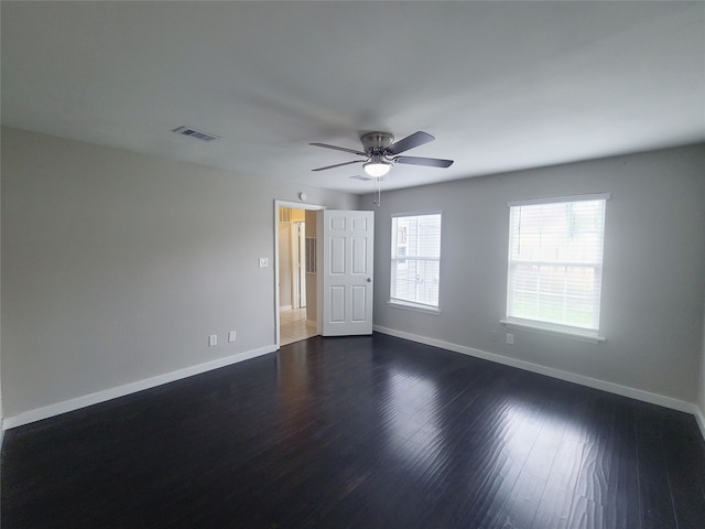 empty room with ceiling fan and dark hardwood / wood-style floors