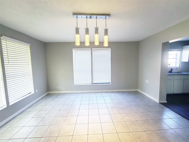 unfurnished dining area featuring light tile patterned floors and sink