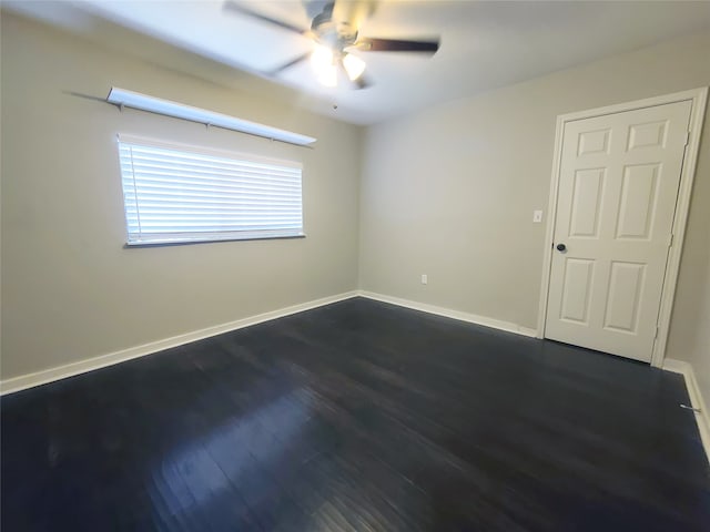 spare room featuring ceiling fan and dark hardwood / wood-style floors