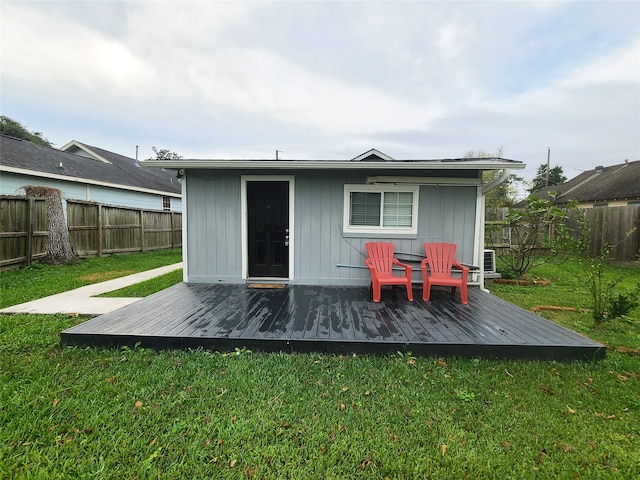 back of house with a wooden deck and a lawn