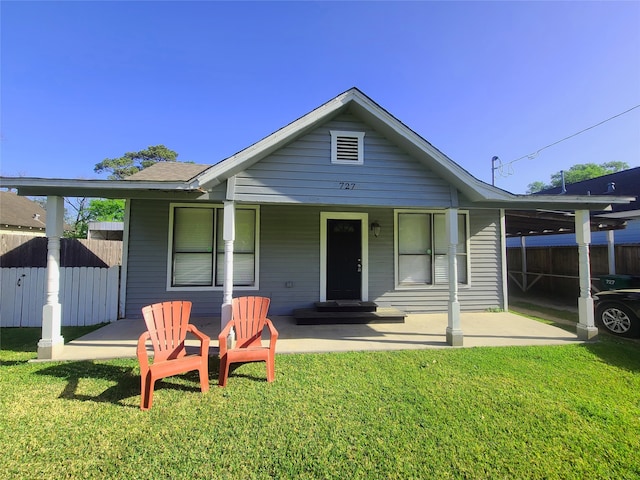 view of front of house with a porch, a front lawn, and a carport