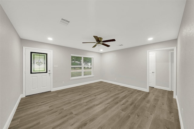 unfurnished living room with wood finished floors, visible vents, and baseboards