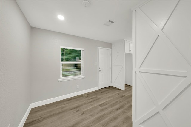 spare room featuring baseboards, visible vents, and light wood finished floors