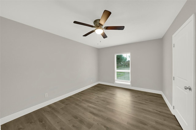 unfurnished room with dark wood-style floors, a ceiling fan, and baseboards
