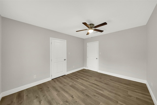 unfurnished room with baseboards, ceiling fan, and wood finished floors