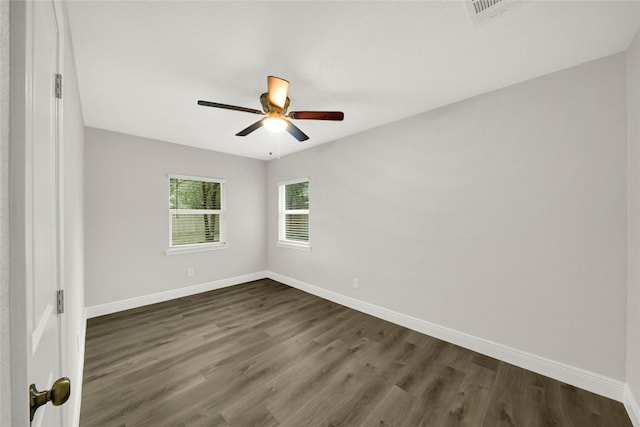spare room with dark wood-type flooring, baseboards, and ceiling fan