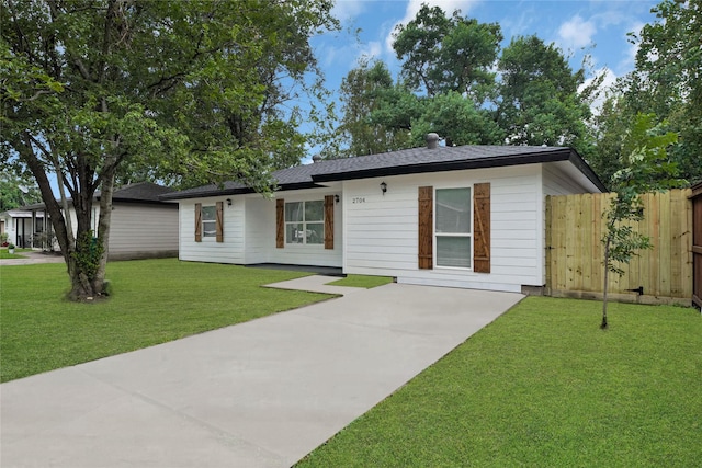 ranch-style home with concrete driveway, a front yard, and fence