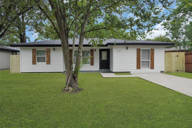 ranch-style house with a front yard and fence