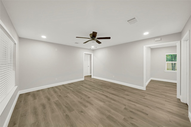 spare room with visible vents, baseboards, a ceiling fan, and wood finished floors
