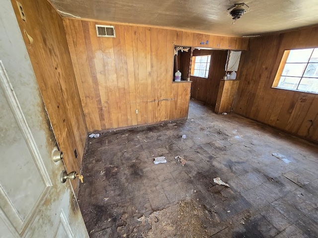 unfurnished room with wood walls