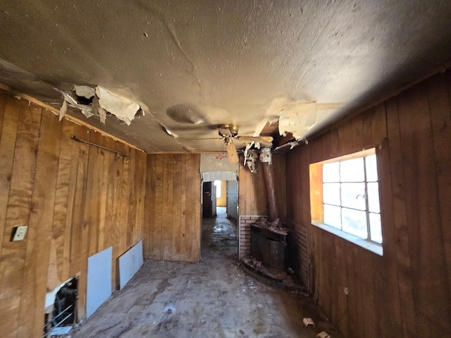 miscellaneous room featuring wood walls and a wood stove