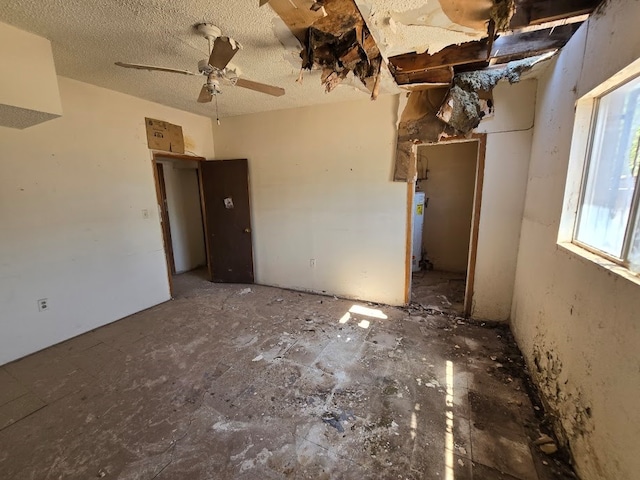 unfurnished room featuring ceiling fan and a textured ceiling