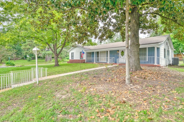 single story home with a front yard, covered porch, and central air condition unit