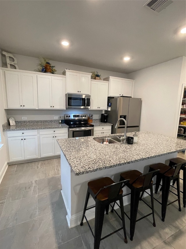 kitchen featuring an island with sink, a breakfast bar area, and stainless steel appliances