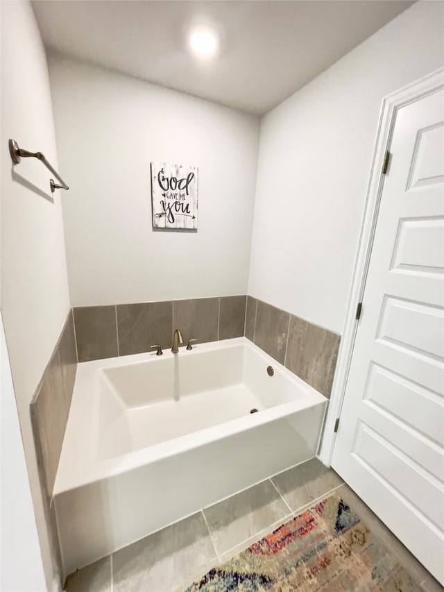 bathroom with a tub to relax in and tile patterned floors